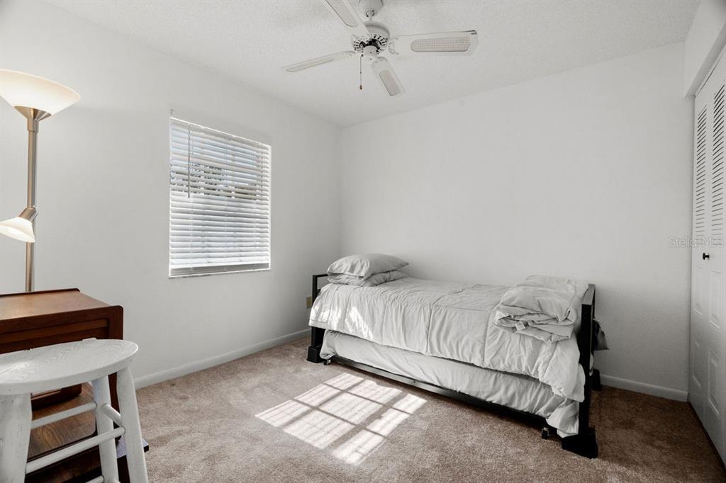 1438 Millstream Lane, Unit 203 Dunedin, FL 34698 - Photo 23 of 60 a bed sitting in a bedroom next to a window