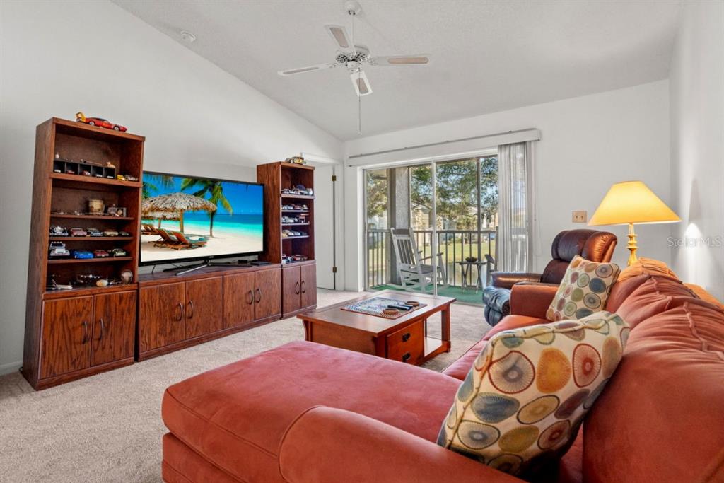 1438 Millstream Lane, Unit 203 Dunedin, FL 34698 - Photo 27 of 60 a bedroom with a bed and wooden floor