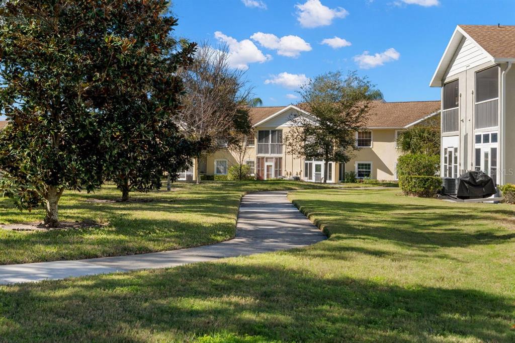 1438 Millstream Lane, Unit 203 Dunedin, FL 34698 - Photo 38 of 60 a front view of a building with a garden