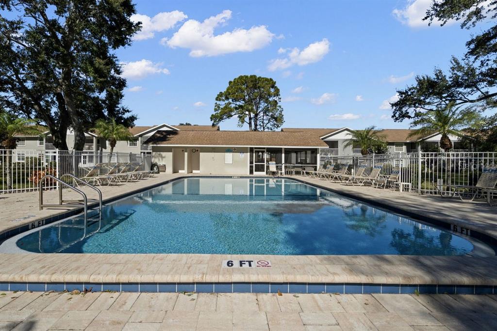 1438 Millstream Lane, Unit 203 Dunedin, FL 34698 - Photo 39 of 60 swimming pool view with a seating space and a garden