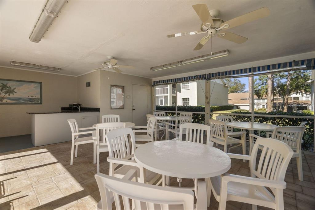 1438 Millstream Lane, Unit 203 Dunedin, FL 34698 - Photo 41 of 60 a view of a dining room with furniture window and wooden floor