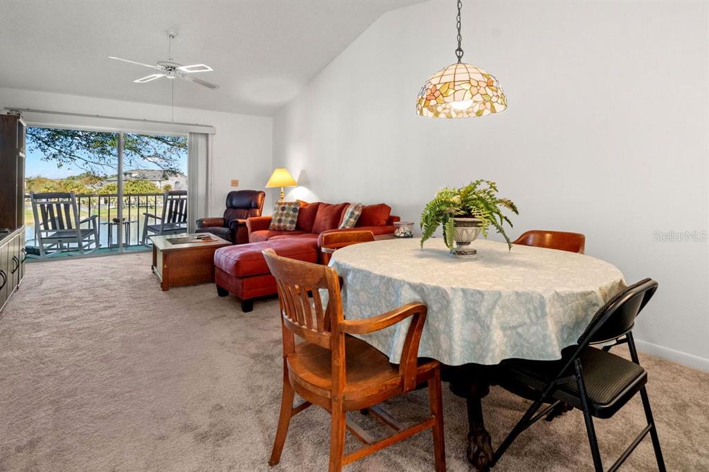 1438 Millstream Lane, Unit 203 Dunedin, FL 34698 - Photo 7 of 60 a view of a dining room with furniture a chandelier and a window