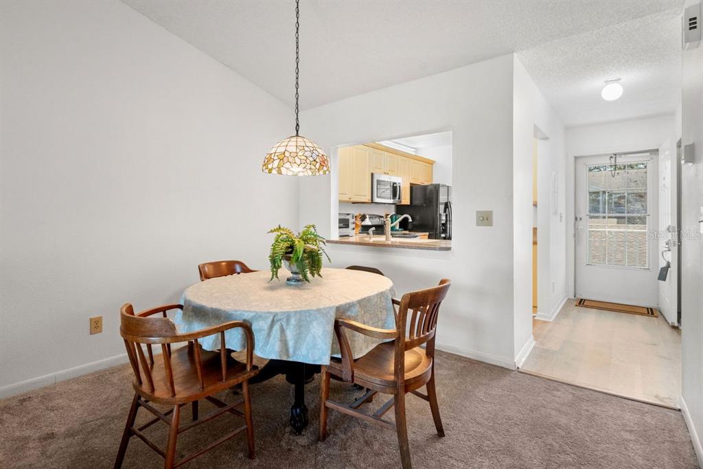 1438 Millstream Lane, Unit 203 Dunedin, FL 34698 - Photo 9 of 60 a view of a dining room with furniture and chandelier
