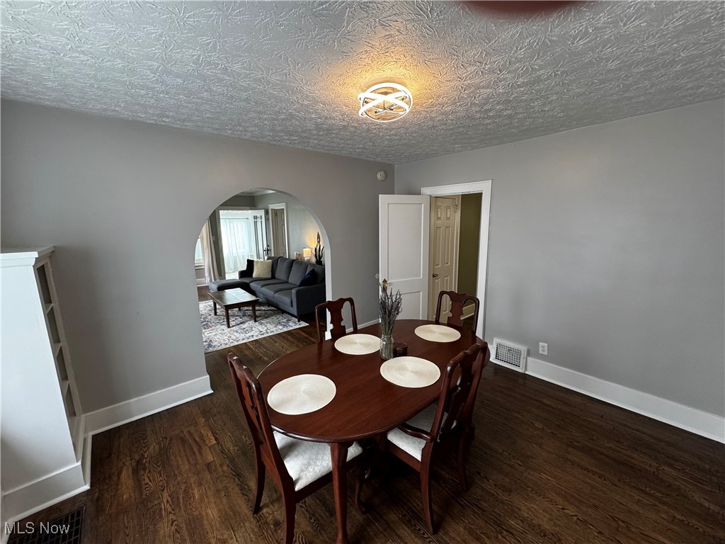 1867 South Cleveland Massillon Road Akron, OH 44321 - Photo 3 of 12 Dining room featuring arched walkways, baseboards, visible vents, and wood finished floors
