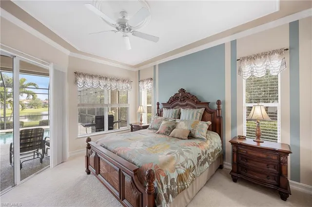 a bedroom with a large bed and a chandelier fan
