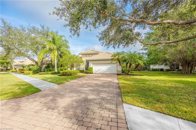 a view of a house with a big yard and palm trees