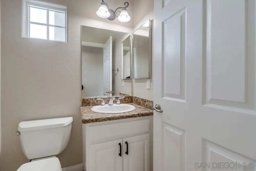 8837 Diamondback Drive Santee, CA 92071 - Photo 15 of 37 a bathroom with a toilet sink and mirror