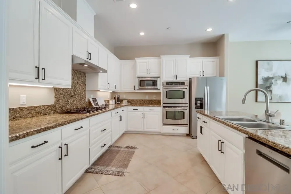 8837 Diamondback Drive Santee, CA 92071 - Photo 2 of 37 a large white kitchen with stainless steel appliances granite countertop a sink and cabinets