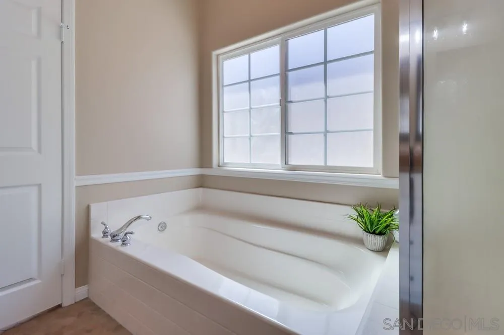 8837 Diamondback Drive Santee, CA 92071 - Photo 22 of 37 a white bath tub sitting in a bathroom next to a window