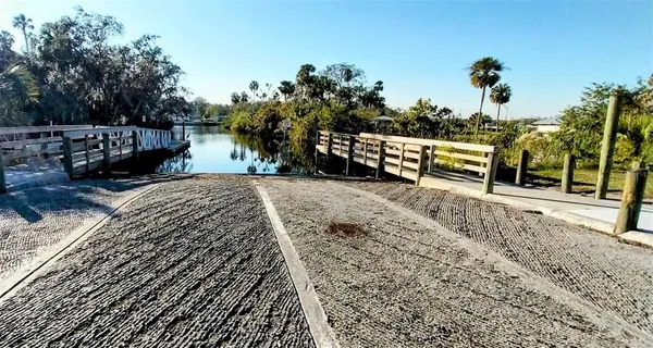 a view of swimming pool with outdoor seating and trees in the background