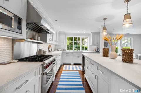 a kitchen with stainless steel appliances a sink a stove and cabinets