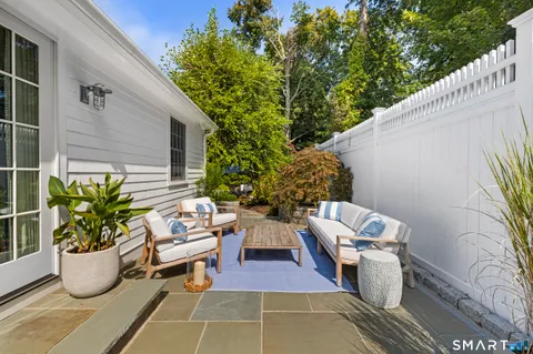 a view of a patio with couches table and chairs and potted plants