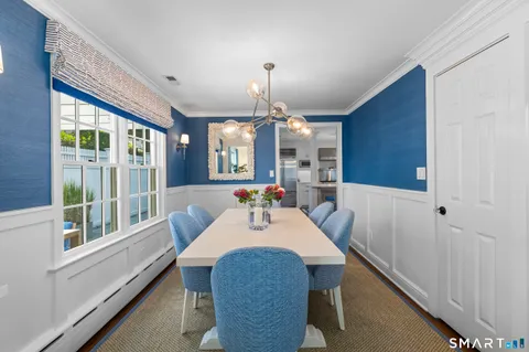 a dining room with furniture a chandelier and wooden floor