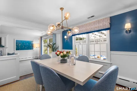 a view of a dining room with furniture a chandelier and wooden floor