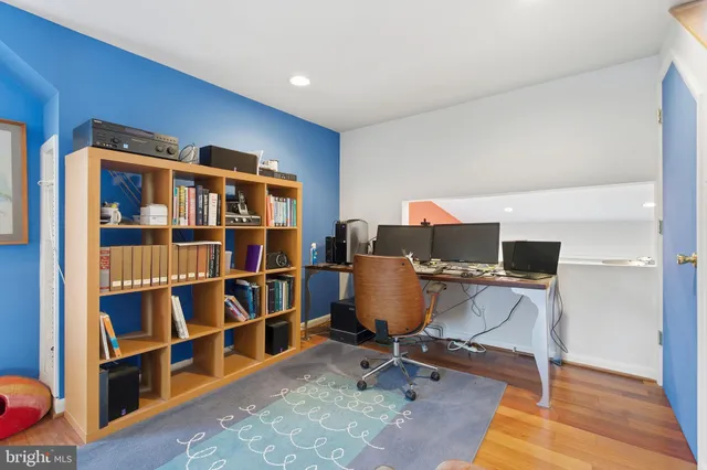 a view of a room with wooden floor wooden floor windows and a ceiling fan