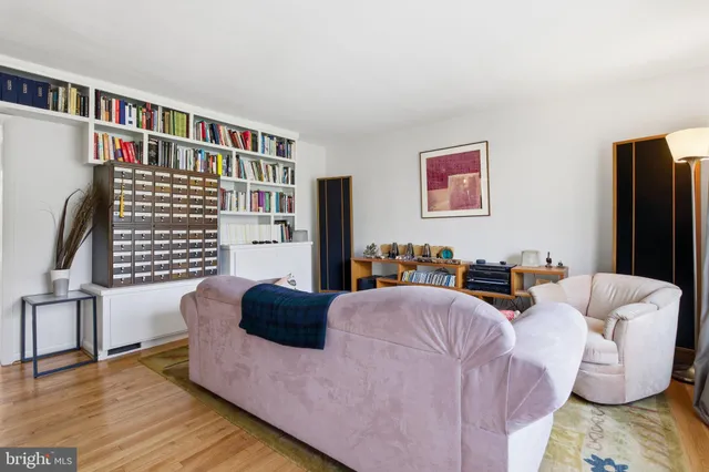 a living room with furniture and a book shelf