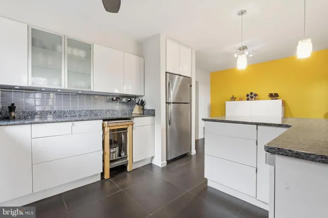 a kitchen with a refrigerator sink and cabinets