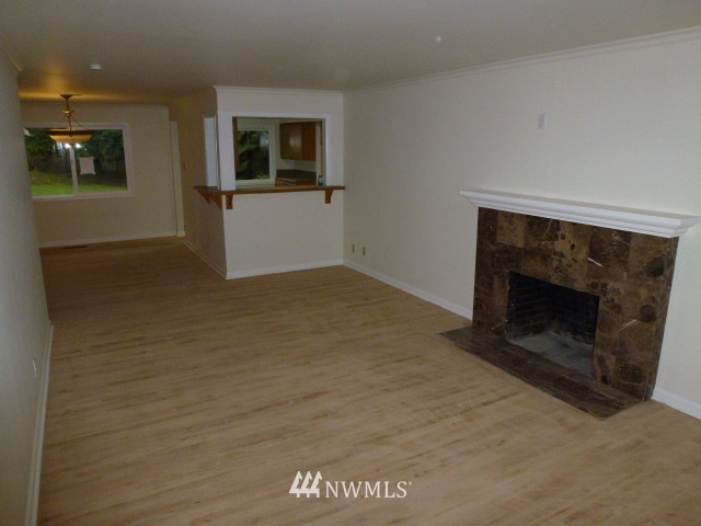 7115 Morgan Road Everett, WA 98203 - Photo 4 of 13 an empty room with windows and fireplace