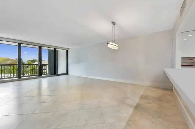 a view of an empty room with a floor to ceiling window and an empty room