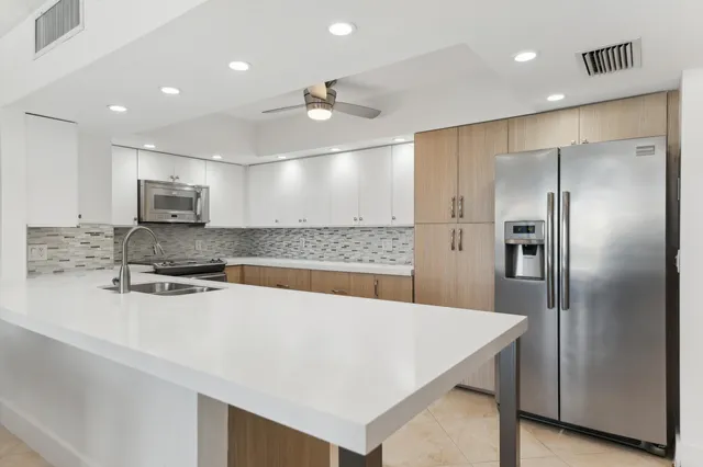 a kitchen with stainless steel appliances a refrigerator sink and microwave