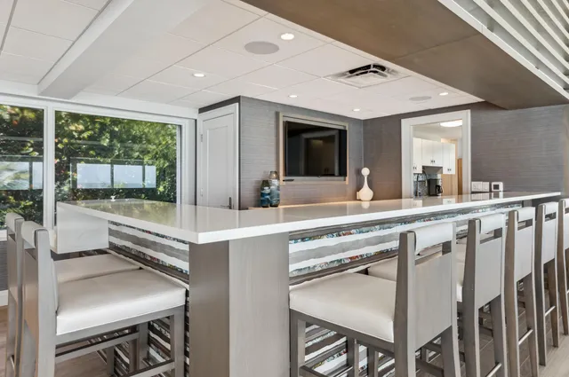a dining hall with stainless steel appliances granite countertop a stove and a sink
