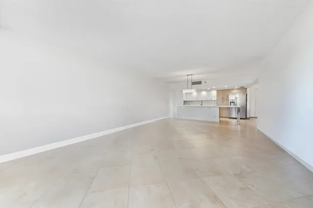 an empty room with windows and cabinet