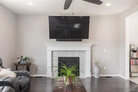 a living room with furniture a flat screen tv and a fireplace