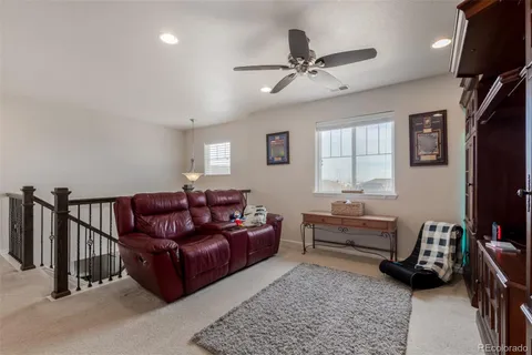 a living room with furniture ceiling fan and a window