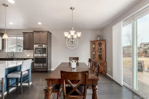 a dining room filled chandelier and wooden floor
