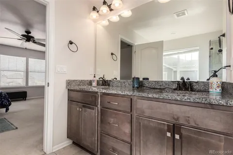 a bathroom with a granite countertop sink a light fixture and a mirror
