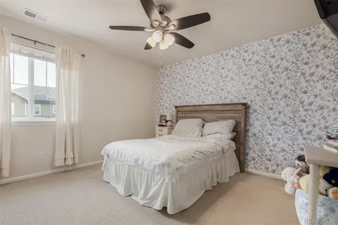 a bedroom with a bed and a ceiling fan