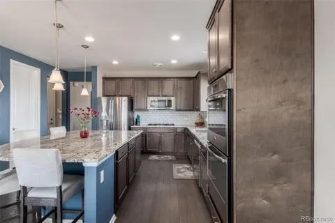 a kitchen with kitchen island granite countertop a large center island and stainless steel appliances