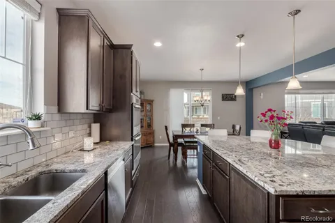 a kitchen with granite countertop a sink stove and cabinets