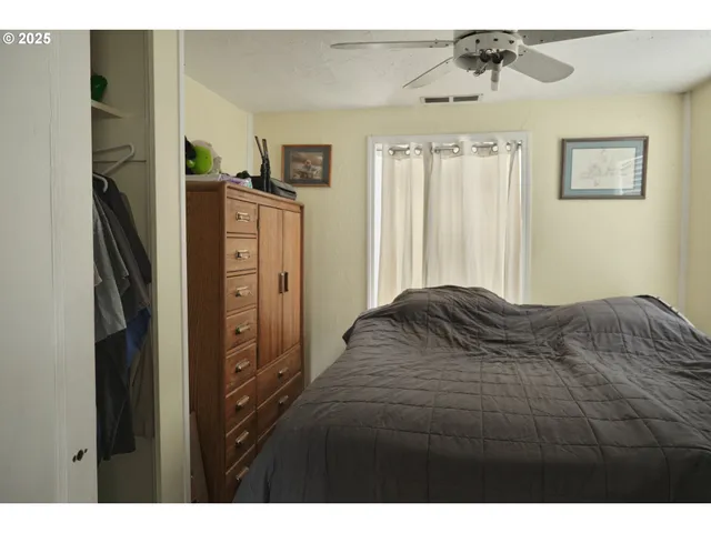 a bedroom with a bed dresser and a window