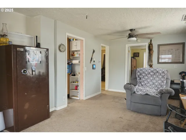 a living room with furniture and a refrigerator