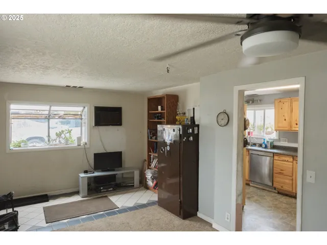 a living room with furniture a flat screen tv and a window