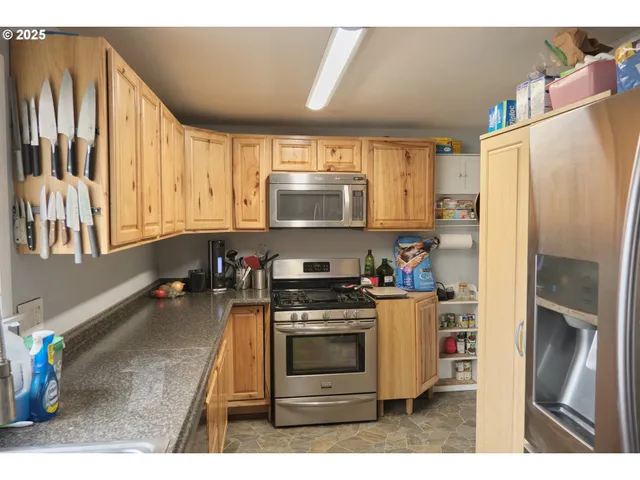 a kitchen with stainless steel appliances a stove a sink and a refrigerator