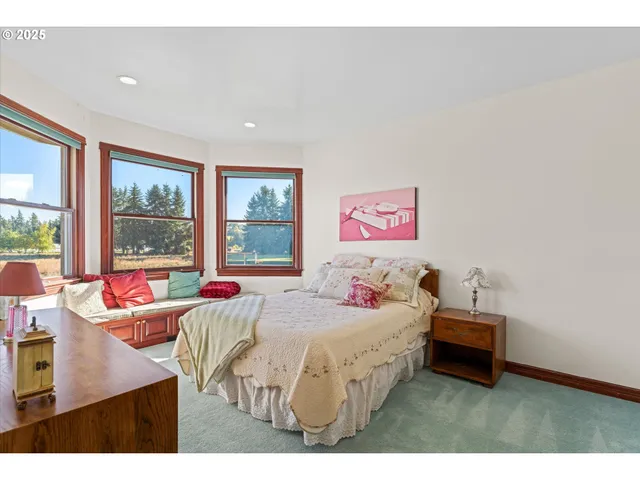 a bedroom with a bed and large windows