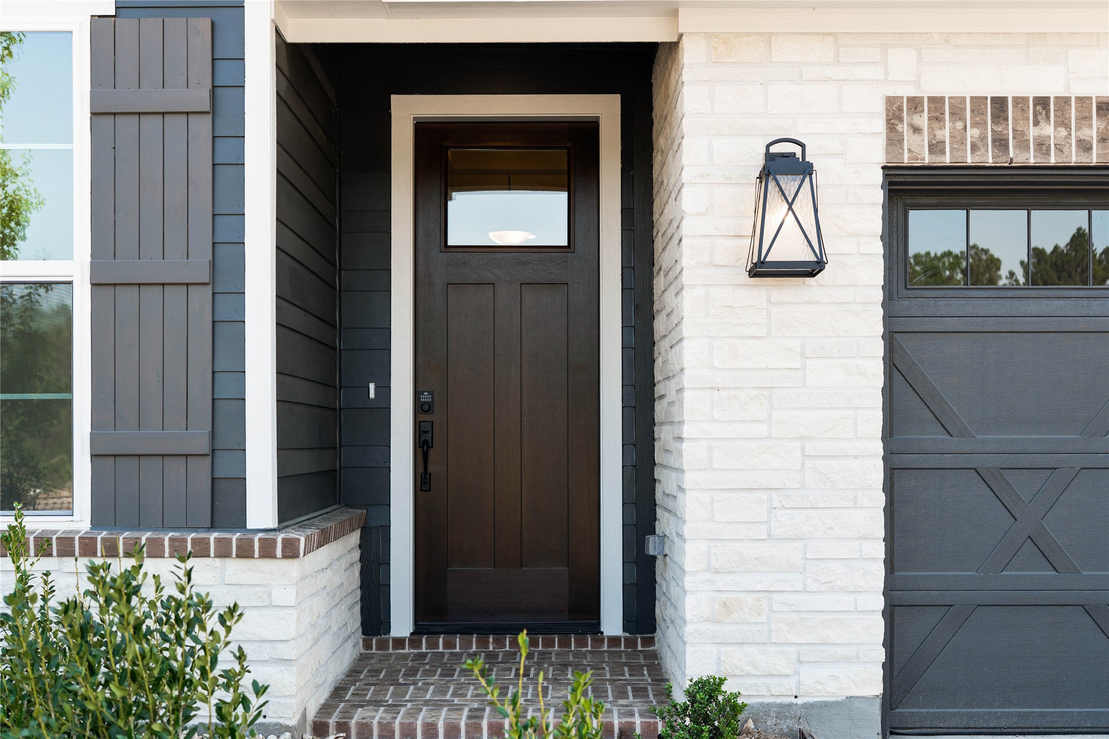 2114 Rowl Street Montgomery, TX 77316 - Photo 6 of 50 Step up to a sophisticated entryway that perfectly captures the modern farmhouse aesthetic. The front porch features timeless brick pavers in a classic running bond pattern, leading to a stately rich espresso craftsman door with a contemporary glass insert.