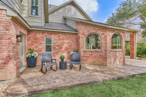 a view of a house with backyard sitting area and a garden