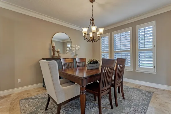 a view of a dining room with furniture a chandelier and wooden floor