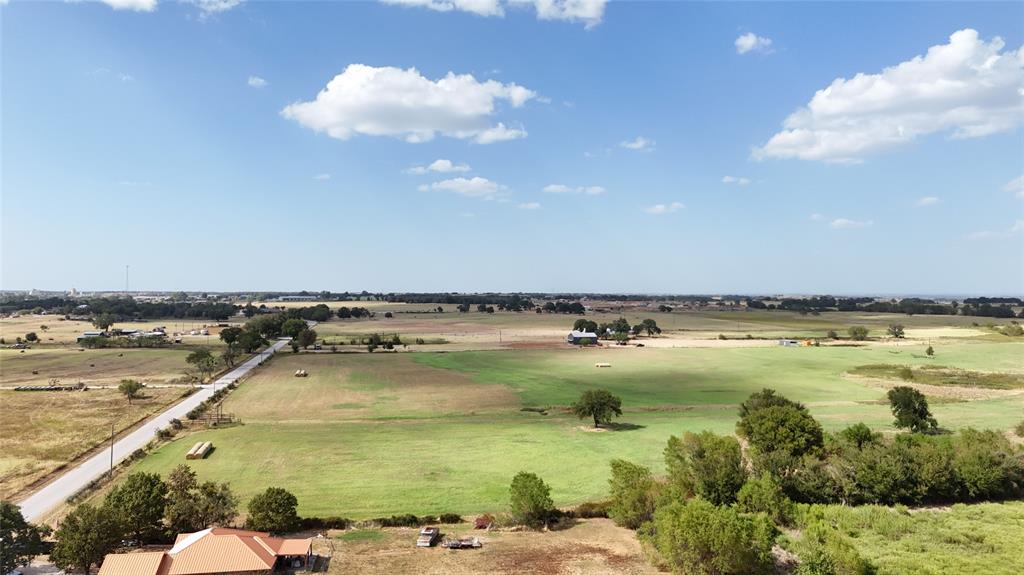 2101 Billings Road Tolar, TX 76476 - Photo 2 of 23 Expansive acreage featuring a paved road, mature trees, and agricultural fields