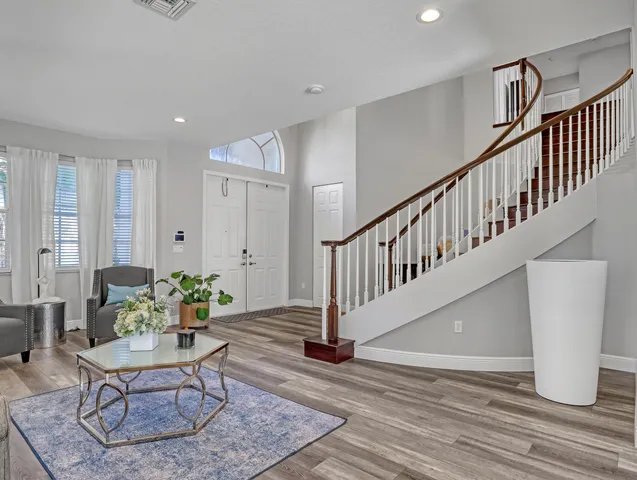 a dining room with furniture a chandelier and wooden floor