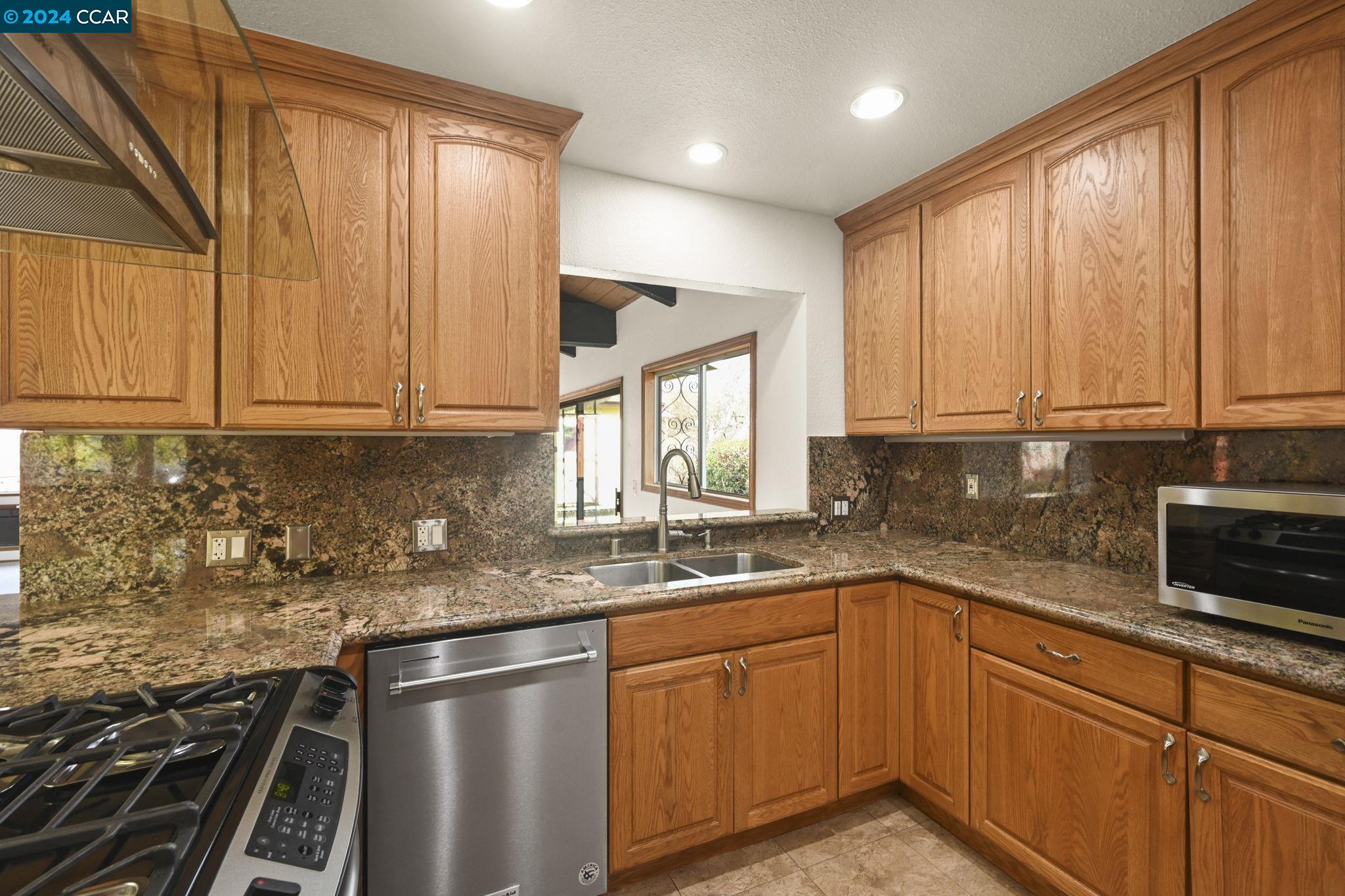 Undisclosed Address Dublin, CA 94568 - Photo 11 of 28 a kitchen with stainless steel appliances granite countertop a sink stove and cabinets