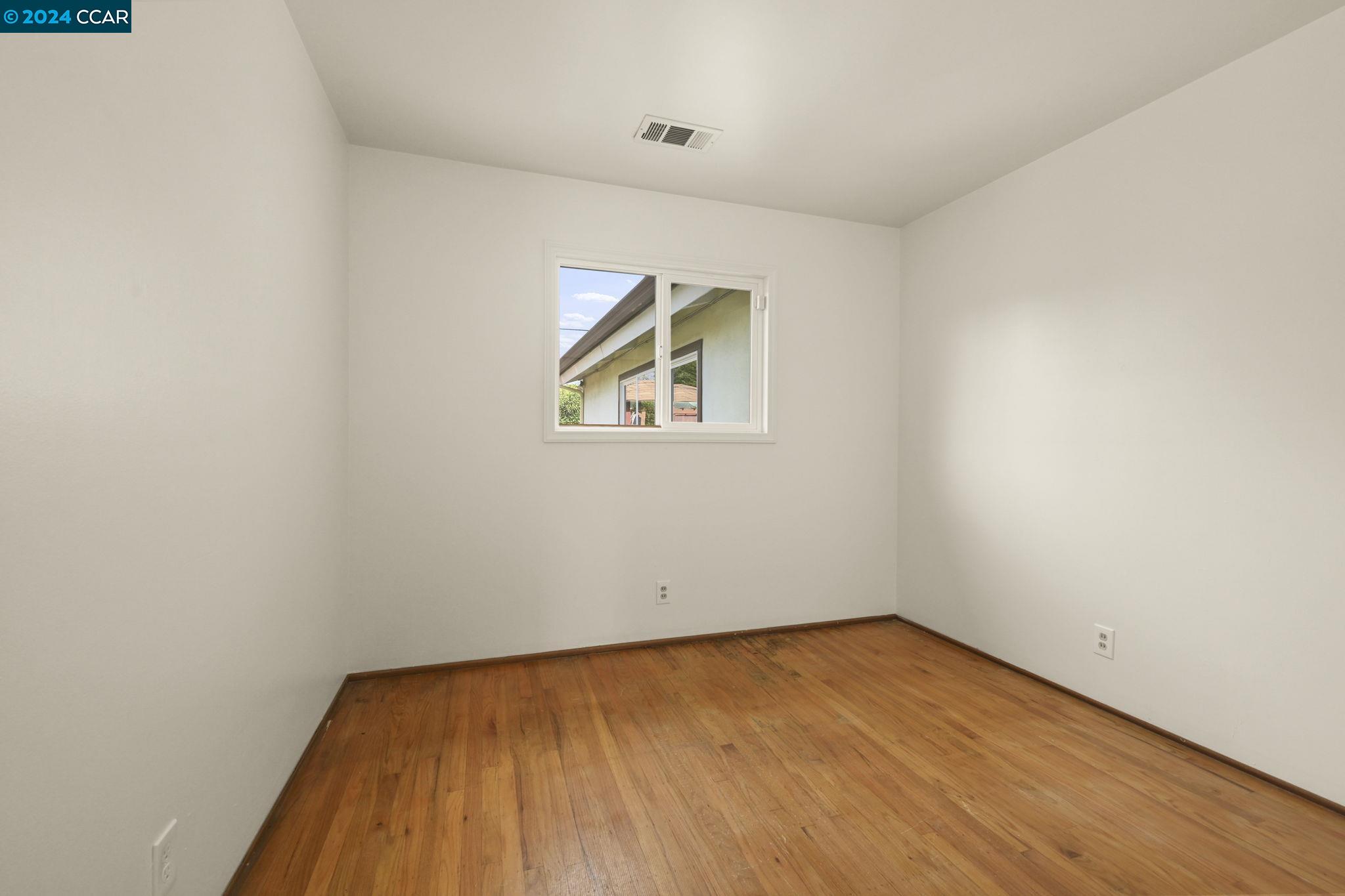 Undisclosed Address Dublin, CA 94568 - Photo 15 of 28 an empty room with a window and wooden floor