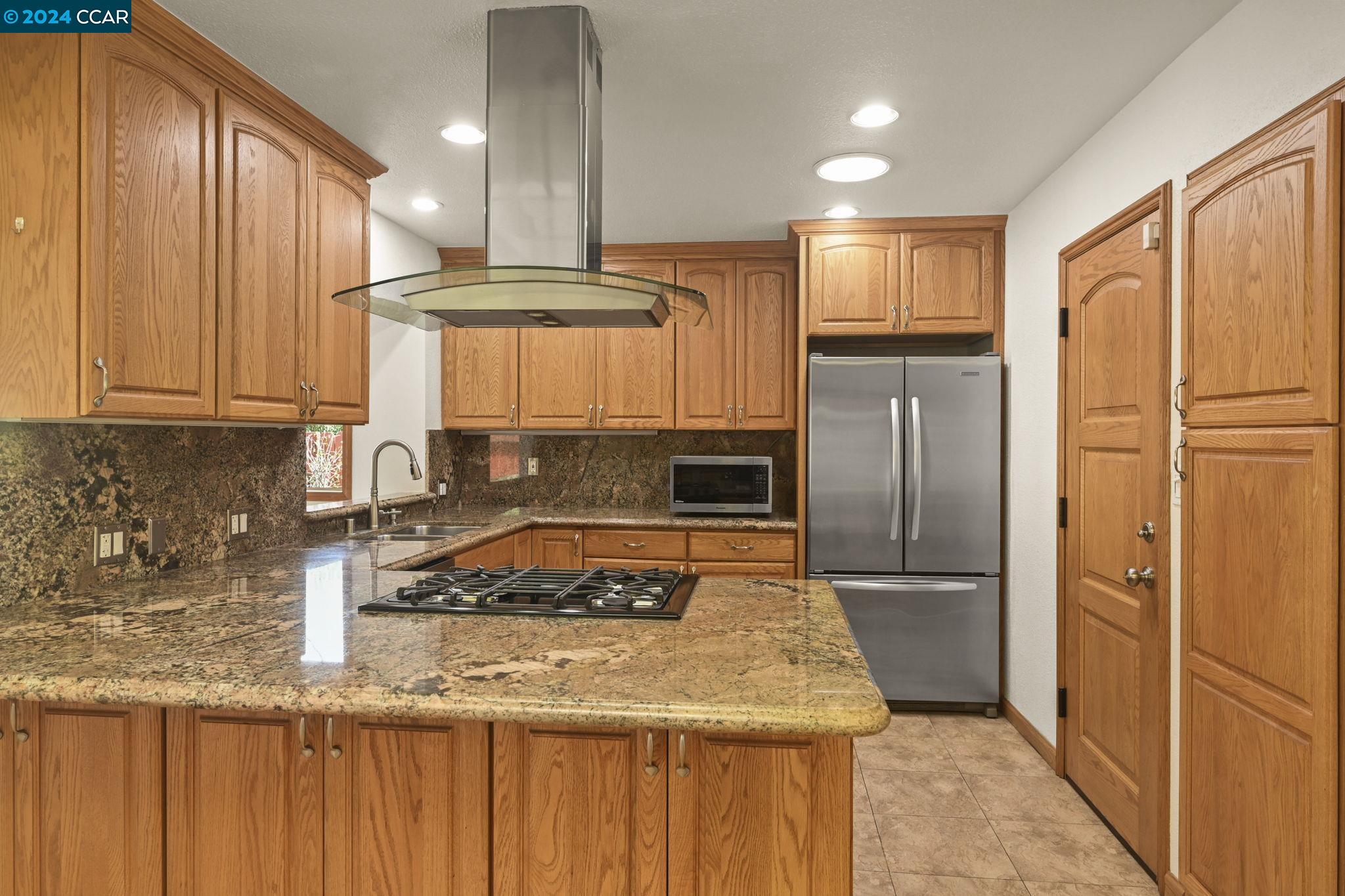 Undisclosed Address Dublin, CA 94568 - Photo 10 of 28 a kitchen with stainless steel appliances granite countertop a refrigerator a sink and a stove with wooden cabinets