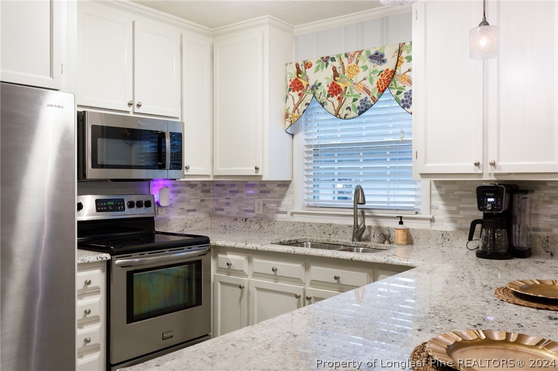 2519 Huntington Road Fayetteville, NC 28303 - Photo 11 of 36 a kitchen with stainless steel appliances granite countertop a stove and a microwave