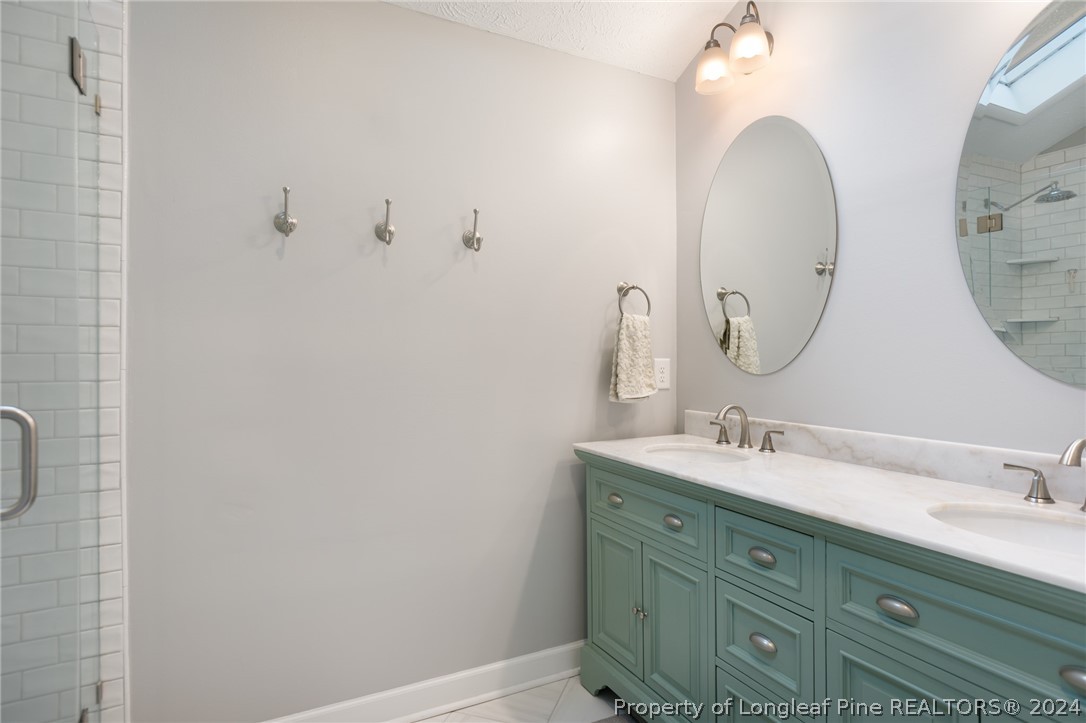 2519 Huntington Road Fayetteville, NC 28303 - Photo 28 of 36 a bathroom with a double vanity sink and a mirror