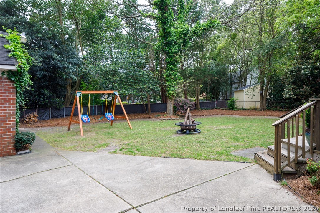2519 Huntington Road Fayetteville, NC 28303 - Photo 34 of 36 a backyard of a house with childrens swings and slides