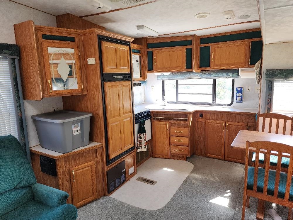 Lot 18 Harrison Creek Road Collbran, CO 81624 - Photo 25 of 30 a kitchen with stainless steel appliances granite countertop a stove a sink dishwasher and a microwave oven with cabinets